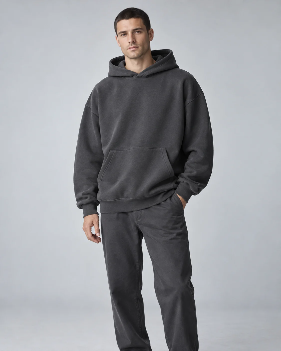 AI-generated hoodie styling concept: adult model in a charcoal pullover hoodie
