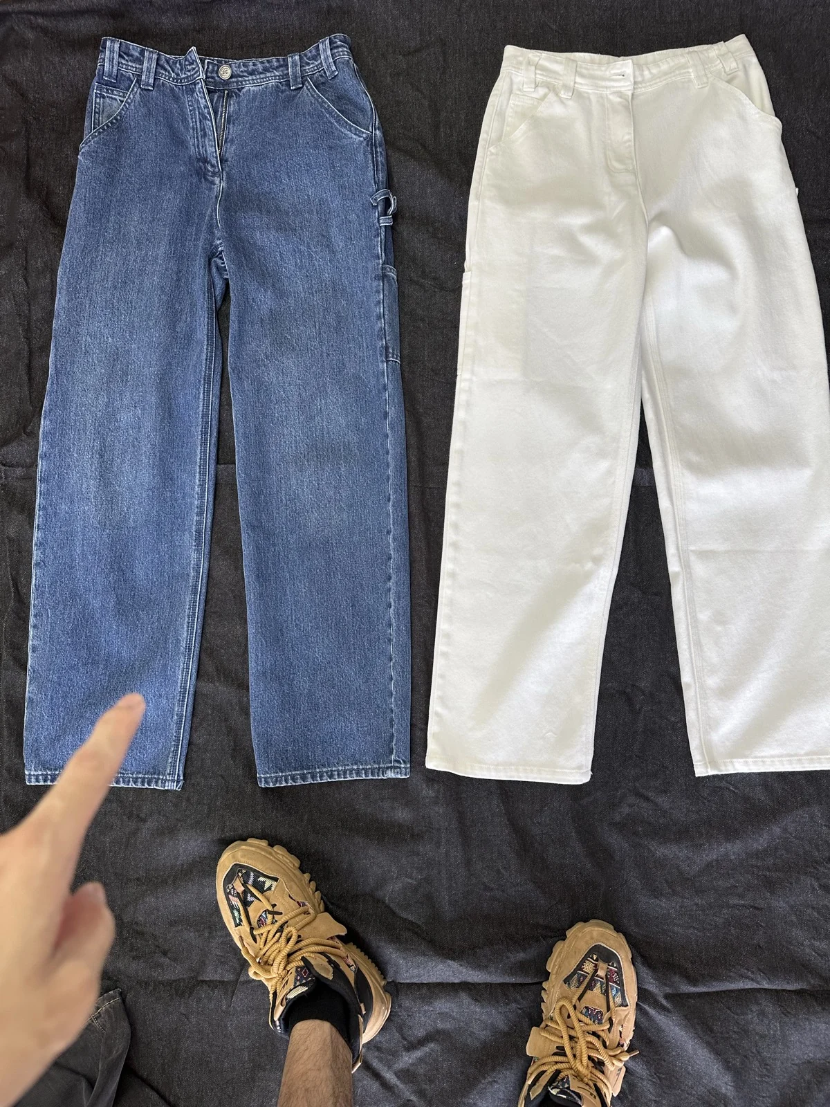 Two photographed trousers in indigo and off-white.