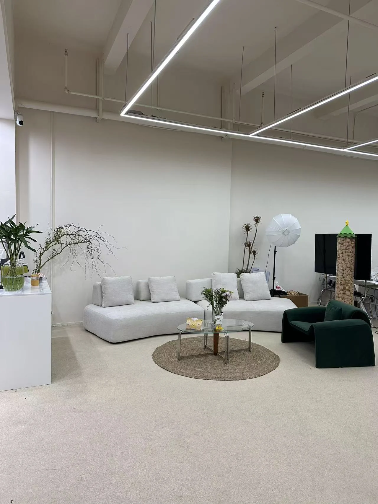 Seasang meeting area with light sofas, a green armchair and a glass table
